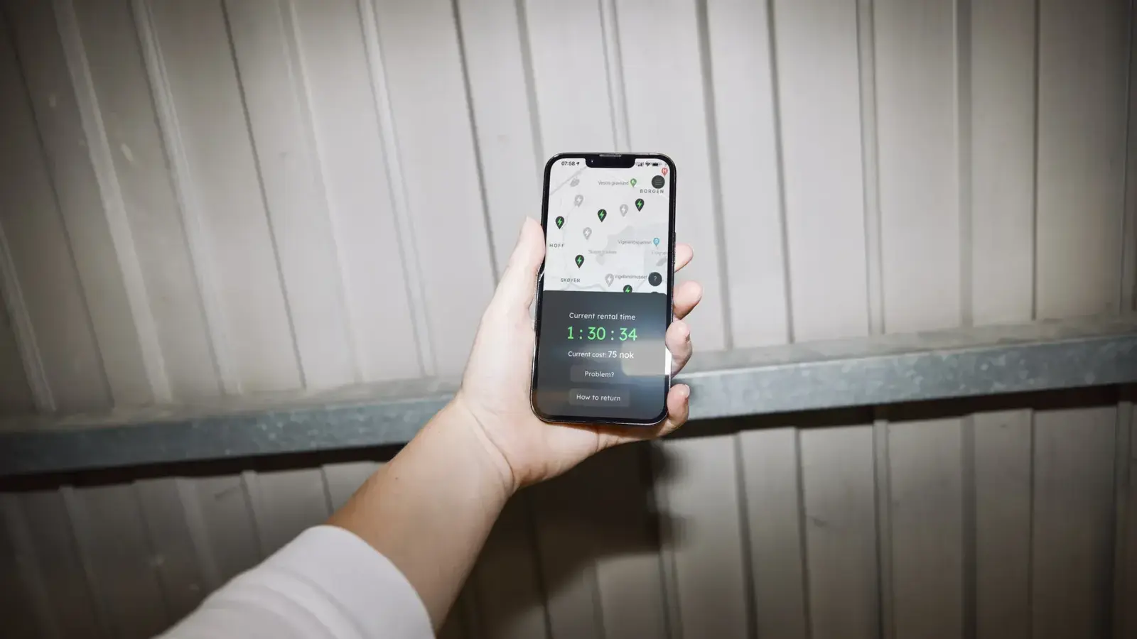 Hånd holder mobiltelefon med Chargo-appen – ladeapp for elbil utviklet av Daytwo
